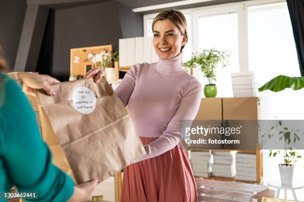 giving customer her sustainably packaged order - care package stock pictures, royalty-free photos & images