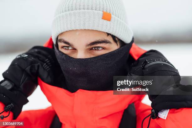 young man wrapped up against the cold - buff stock pictures, royalty-free photos & images