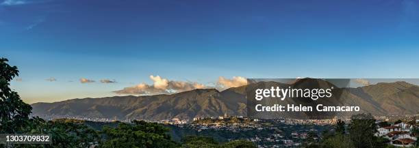 panoramic view of caracas city at sunset with el avila at the background - caracas foto e immagini stock