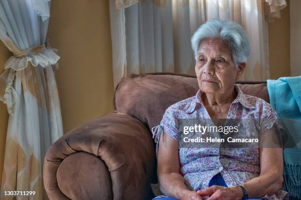 sad senior woman sitting on the sofa. - serious illness stock pictures, royalty-free photos & images