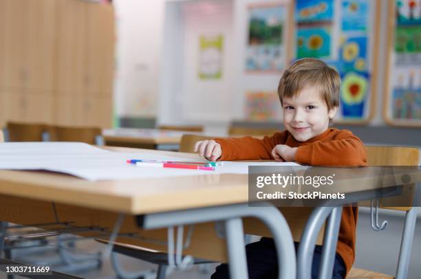 portrait of schoolboy sitting in the classroom - tiny 7 stock pictures, royalty-free photos & images