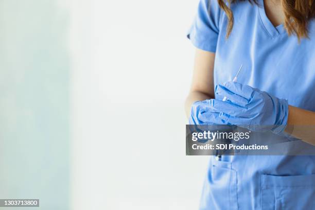 unrecognizable female healthcare professional holds syringe with vaccine - scarce stock pictures, royalty-free photos & images