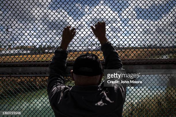 Man looks upon the Rio Grande while waiting to show his immigration documents to U.S. Immigration officers at the U.S.-Mexico border crossing on...