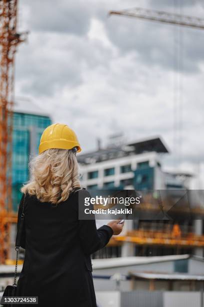 de bouwmanager die van de vrouw werken op de bouwwerf controleert - architecte plan stockfoto's en -beelden