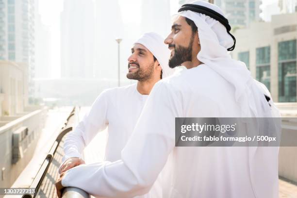 two arabic men walking together in city,dubai,united arab emirates - arabic people ストックフォトと画像