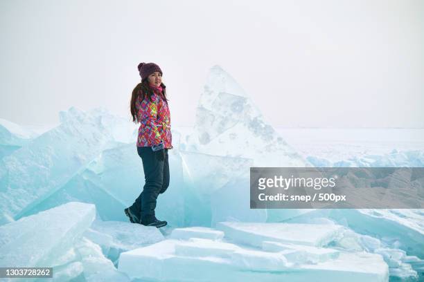 woman standing on glacier against sky - arctic explorer stock pictures, royalty-free photos & images