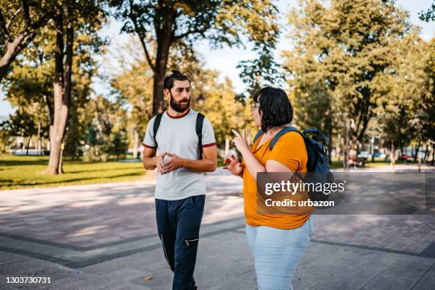 two young people speak in sign language - man walking in a park stock pictures, royalty-free photos & images