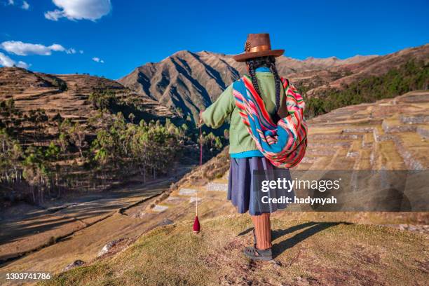 mujer peruana girando lana a mano, valle sagrado, perú - quechuas fotografías e imágenes de stock