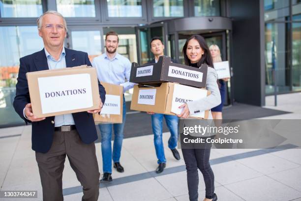 businesspeople collecting donations. - international humanitarian aid stock pictures, royalty-free photos & images