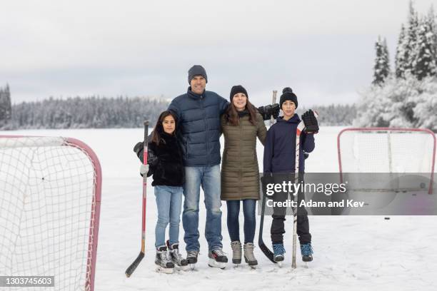 portrait of family in ice-skates on outdoor ice rink - hockey mom stock pictures, royalty-free photos & images