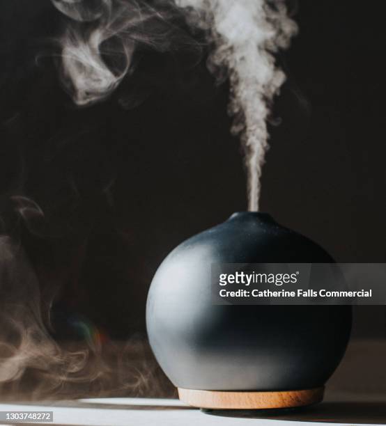 a thick mist gently rises from an oil diffuser, used in aromatherapy - aromatherapy imagens e fotografias de stock