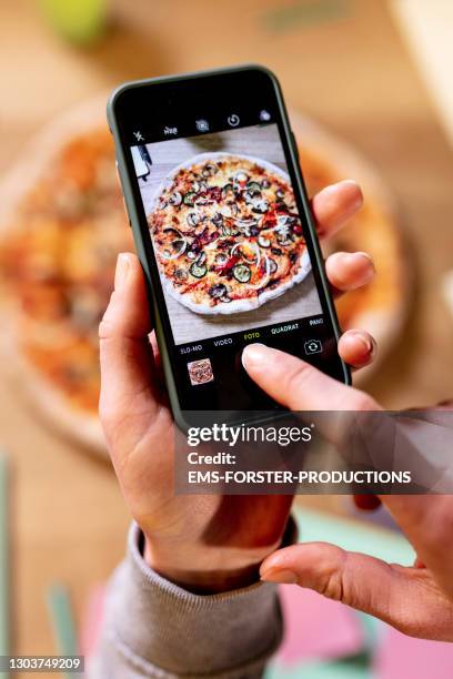 female hand with cell phone taking pictures of pizza - prendre photo photos et images de collection