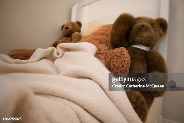 three oversized stuffed toy teddy bears in little girl’s bed - goldilocks fotografías e imágenes de stock