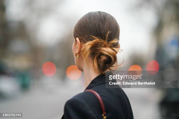 Olesya Senchenko wears earrings, a black oversized blazer jacket from Lanvin, on February 22, 2021 in Paris, France.