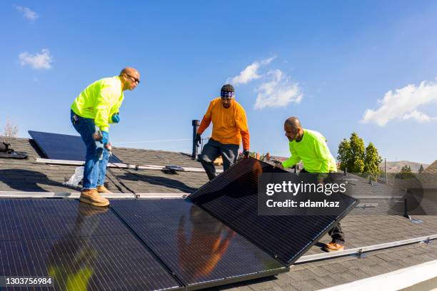 equipo de trabajadores instala paneles solares en azotea residencial en california - energía solar fotografías e imágenes de stock