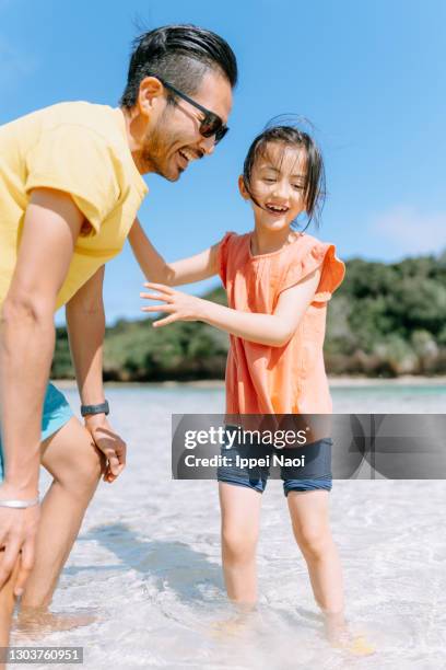 father and young daughter playing in shallow tropical water - standing water ストックフォトと画像