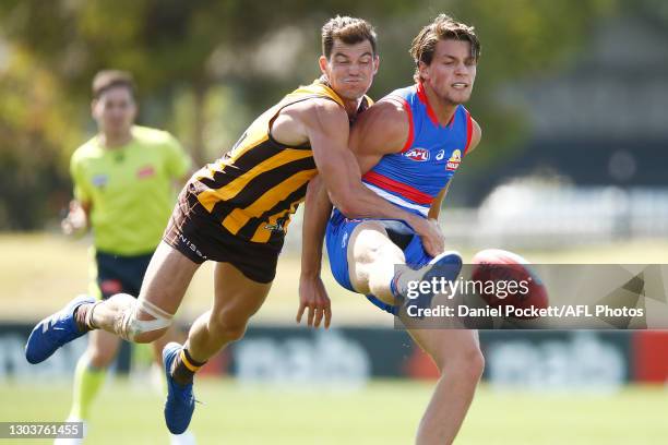 Patrick Lipinski of the Bulldogs kicks the ball whilst being tackled by Jaeger O'Meara of the Hawks during the AFL Practice Match between the Western...