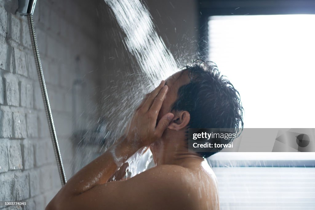 Handsome asian guy Taking a shower in the bathroom