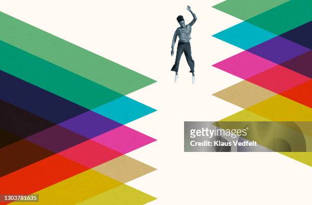 young woman falling amidst colorful pattern - multi coloured trousers stockfoto's en -beelden