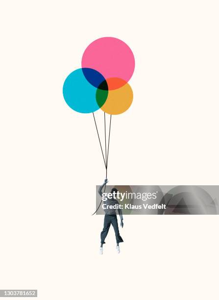woman hanging from colorful helium balloons - woman hanging balloon stock pictures, royalty-free photos & images