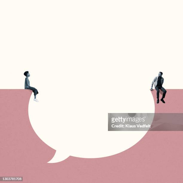 man and woman sitting around large thought bubble - parlare foto e immagini stock