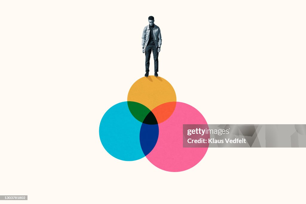 Young man standing on top venn diagram of colorful circles
