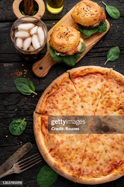 tasty hamburger and pizza on dark table - pizza burgers stock pictures, royalty-free photos & images