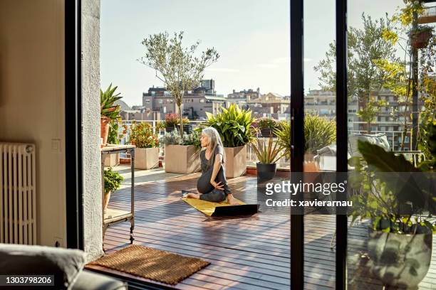 rentnerin genießt yoga auf sunny outdoor deck - garden decking stock-fotos und bilder