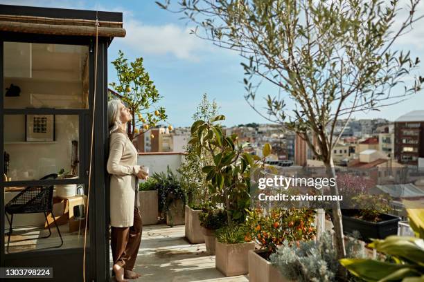 femme caucasien à la retraite appréciant le café et le soleil sur le pont - balcony photos et images de collection