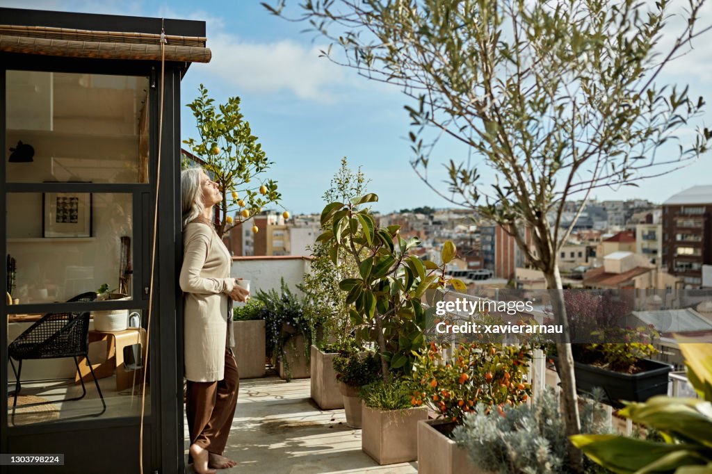 Retired Caucasian Woman Enjoying Coffee and Sunshine on Deck