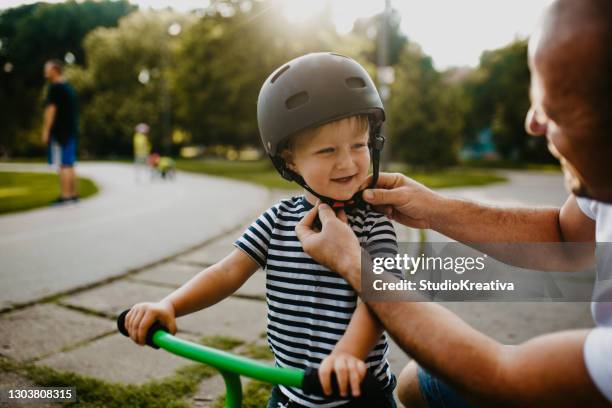 kleiner junge lernt fahrrad fahren - child and parent and bike stock-fotos und bilder