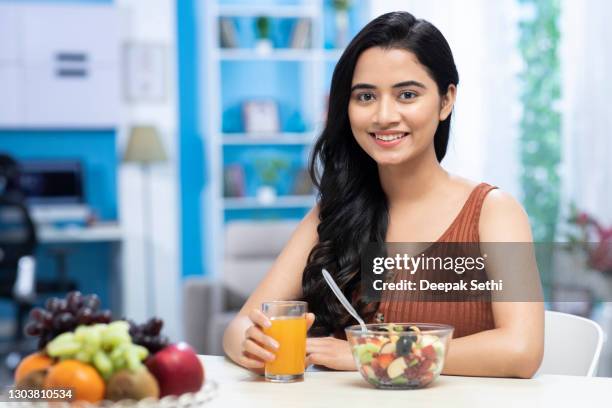 young women drinking orange juice and eating  fruit salad  stock photo - healthy eating stock pictures, royalty-free photos & images