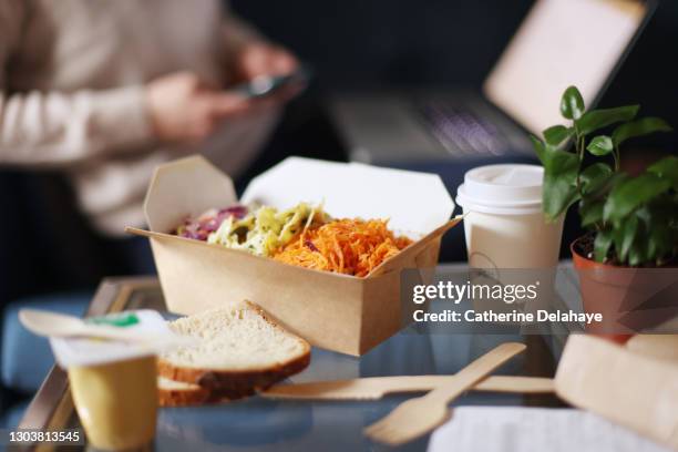close-up of takeaway meal with woman working in the background - catering stock-fotos und bilder