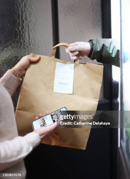 close up of woman receiving take away food delivery - food delivery fotografías e imágenes de stock