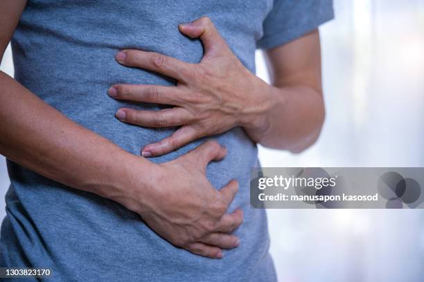 a man with a stomachache - buikpijn stockfoto's en -beelden