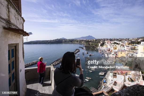 Tourists taking pictures of Marina di Corricella. Procida , February 6th 2021