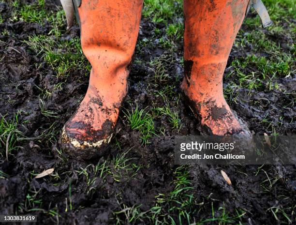 a woman with very muddy orange wellies - dirty feet stock-fotos und bilder