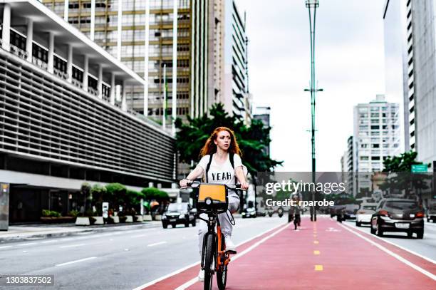 a young woman cycling down avenida paulista - avenida paulista stock pictures, royalty-free photos & images