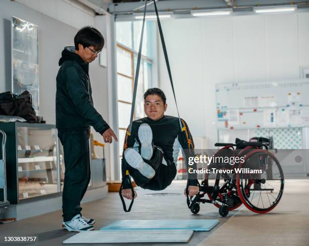 paraplegic athlete training in a gym with his coach - disabled athlete foto e immagini stock