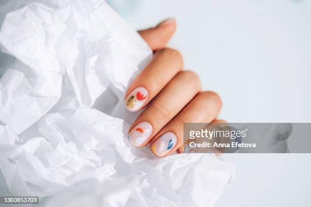 woman hand with beautiful colorful manicure is holding white paper. trendy bright colors of the year - nail varnish stockfoto's en -beelden