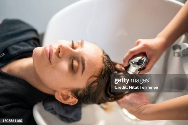 young women customer washing her hair by beautician after dye hair at beauty salon.  beauty salon business. - beauty salon stock pictures, royalty-free photos & images