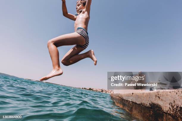 boy jumping into sea - floating piers ストックフォトと画像