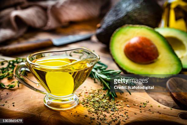 avocado oil on rustic wooden table - avocado oil stock pictures, royalty-free photos & images