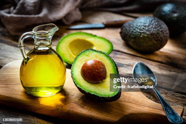 avocado oil on rustic wooden table - avocado oil stock pictures, royalty-free photos & images