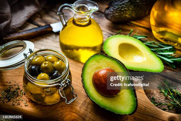 natives olivenöl extra und avocadoöl auf rustikalem holztisch - avocado stock-fotos und bilder