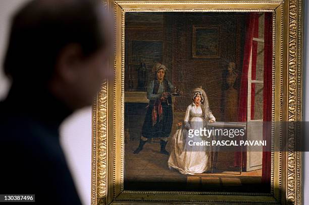 Man looks at a painting by French artist Jacques Sablet "Portrait of Letizia Bonaparte, aka Madame Mère" as part of the exhibition "Petits Theatre de...