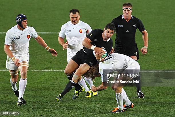 Stephen Donald of the All Blacks is tackled by Aurelien Rougerie of France during the 2011 IRB Rugby World Cup Final match between France and New...