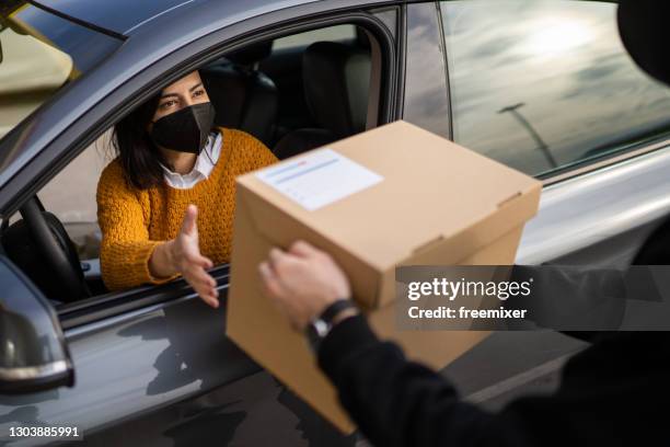 戴著面罩的女人在路邊的皮卡上從車裡取貨 - curbside pickup 個照片及圖片檔
