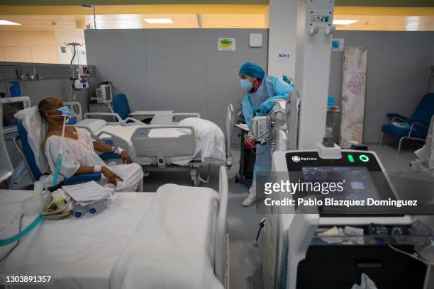 Healthcare worker wearing PPE uses a mobile x-ray machine with a Covid-19 patient at the intermediate respiratory care unit in Nurse Isabel Zendal...