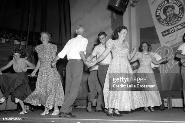 Square dancers accompanied by June Carter Cash on stage at the Grand Ole Opry circa 1951 in Nashville, Tennessee.